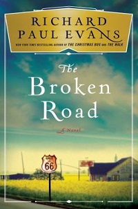 book cover for the broken road by richard paul evans: a route 66 sign in the foreground with a field and an old building in the background.